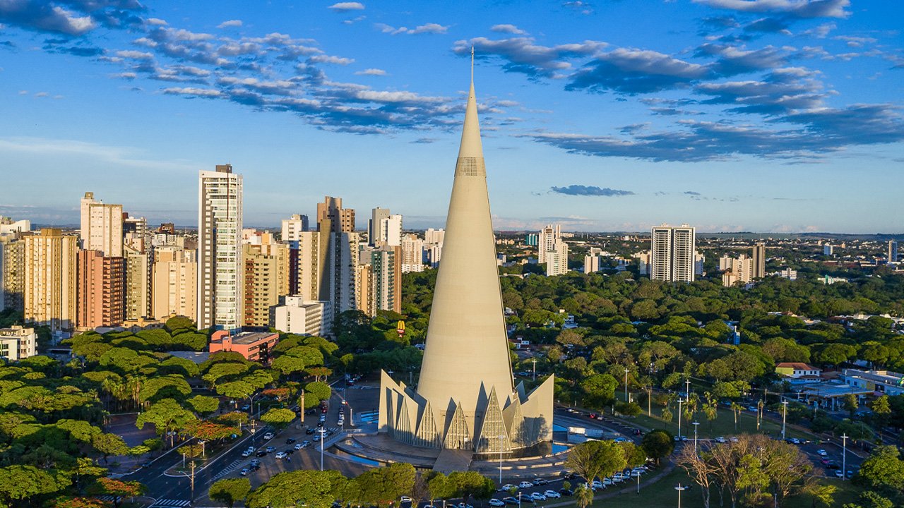 A modern, abstract architectural detail or cityscape representing Maringá, Brazil. High-contrast, vibrant, with subtle neon lighting accents against a bright sky to maintain the energetic, modern travel aesthetic. The image serves as an engaging backdrop.