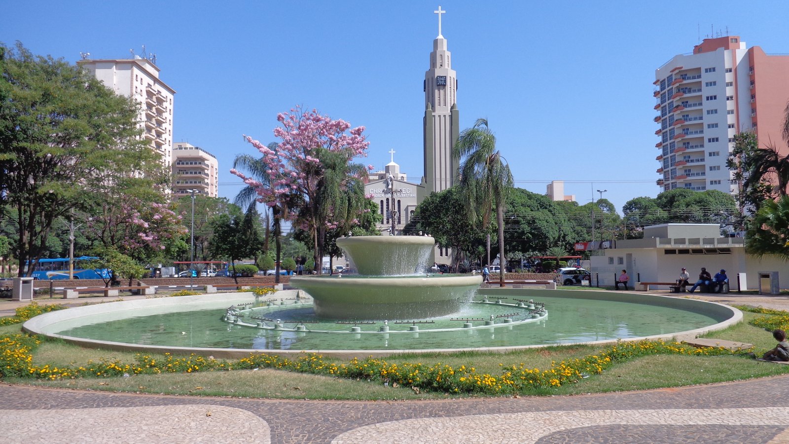 A modern, abstract architectural detail or cityscape representing Presidente Prudente, Brazil. High-contrast, vibrant, with subtle neon lighting accents against a bright sky to maintain the energetic, modern travel aesthetic. The image serves as an engaging backdrop.